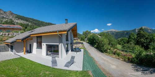 a house with a porch and a driveway at Chalet Soleil Bœuf et Spa de l'adouss in Saint-Jean-Saint-Nicolas