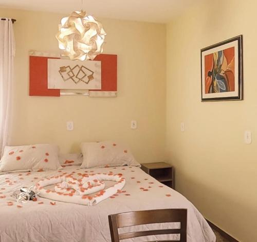 a bedroom with a bed with a heart decoration on it at Chalés Caminho das Montanhas in Monte Verde