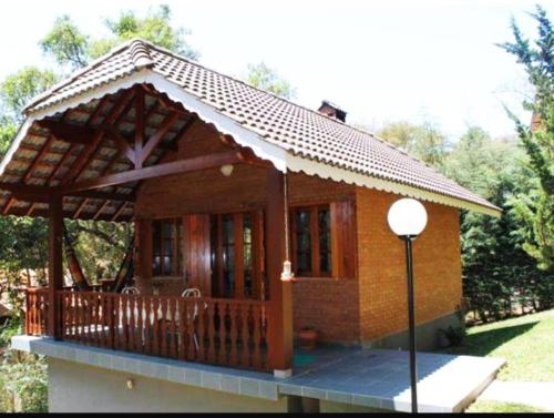 a small house with a porch with a roof at Chalés Caminho das Montanhas in Monte Verde