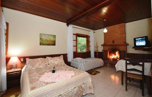 a bedroom with a bed and a fireplace at Chalés Caminho das Montanhas in Monte Verde