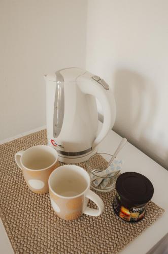 a coffee maker and two cups on a counter at Lefteris Rooms in Kámbos