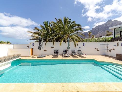 a swimming pool in a villa with mountains in the background at Casa Susanne in Famara