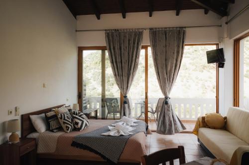a living room with a bed and a couch at Lefteris Rooms in Kámbos