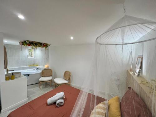 - une chambre avec un lit à baldaquin et une baignoire dans l'établissement Charmante escapade, à Perpignan