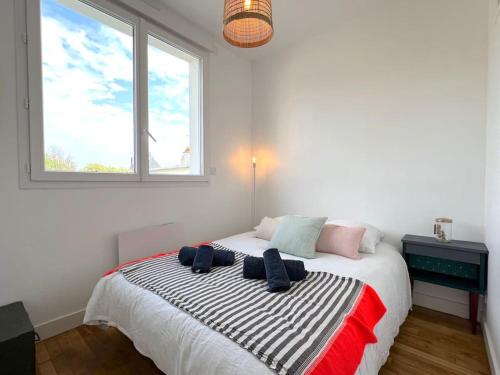 une chambre avec un grand lit avec une fenêtre dans l'établissement Le California ! 250m des plages, à Larmor-Plage