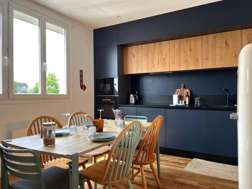 - une cuisine avec une table et des chaises en bois dans l'établissement Le California ! 250m des plages, à Larmor-Plage