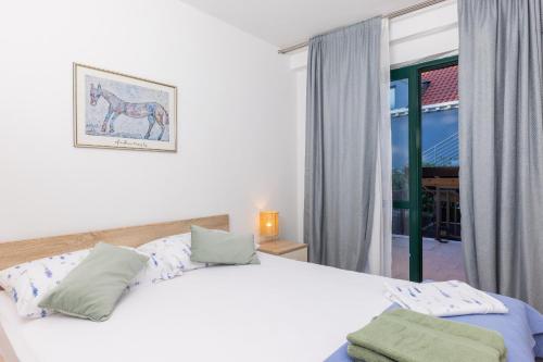 a bedroom with a white bed and a window at Pietro in Korčula