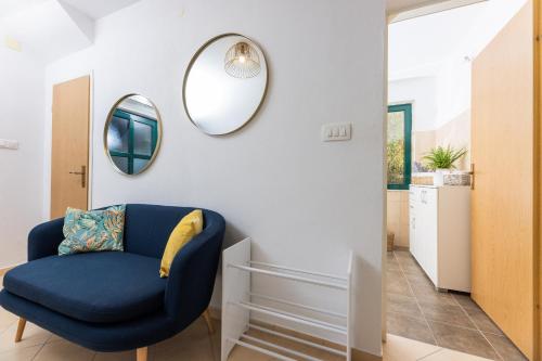 a living room with a blue chair and mirrors at Pietro in Korčula