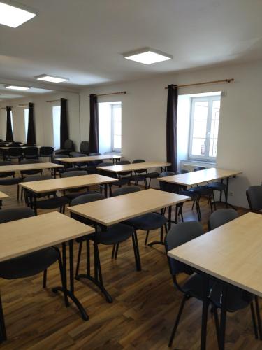 an empty classroom with rows of tables and chairs at Penzion U tri statkaru in Dobříš