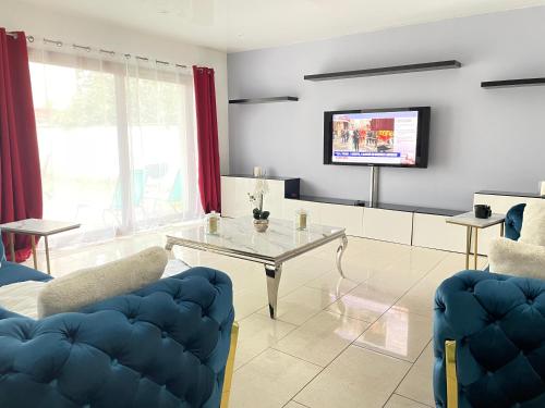 a living room with a table and a tv at Villa d'architecte 4 chambres 9 Personnes Proche Disney Paris in Le Perreux-Sur-Marne