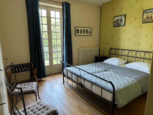 a bedroom with a bed and a chair and a window at Villa Moncoeur in Remiremont