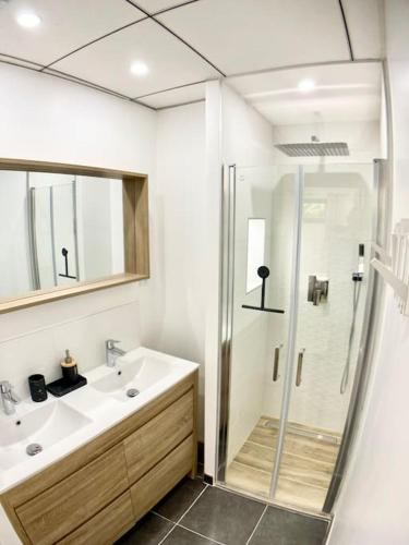 une salle de bain blanche avec une douche et un lavabo dans l'établissement Charmante Maison indépendante entre ville et mer, à Montpellier