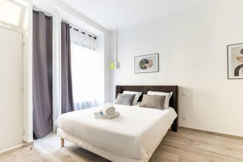 une chambre avec un grand lit blanc avec une fenêtre dans l'établissement Ballu Place de Clichy Cosy Studio, à Paris