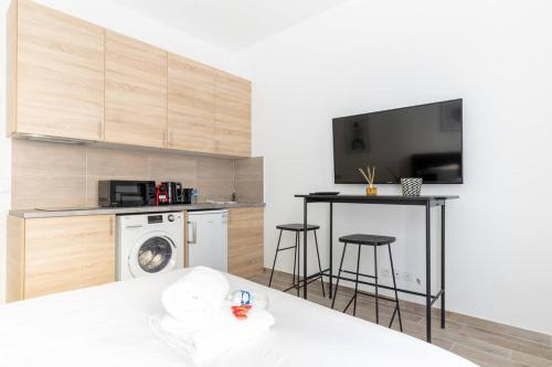 Cette chambre comprend une cuisine équipée d'un lave-linge et une télévision. dans l'établissement Ballu Place de Clichy Cosy Studio, à Paris