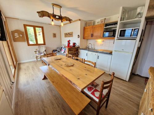 une cuisine et une salle à manger avec une table en bois dans l'établissement Appart 4 pièces, 8 pers, proche piste, Valfréjus - FR-1-265-328, à Modane