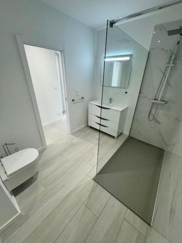 une salle de bain avec toilettes et douche en verre dans l'établissement Appartement meublé de 120 m2, à Coudun