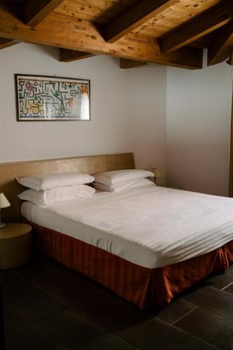 a bed with white sheets and pillows in a room at Residence Carlton in Ferrara