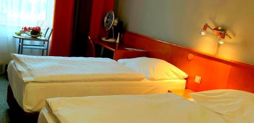 a hotel room with two beds and a table at Hotel Tennis Club in Prostějov