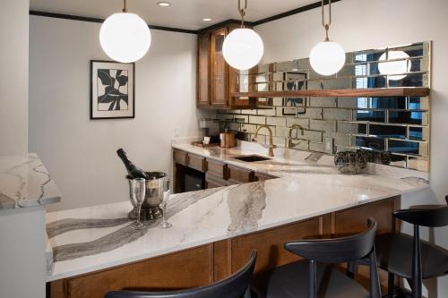 a kitchen with a counter and some stools at The Ansonborough in Charleston