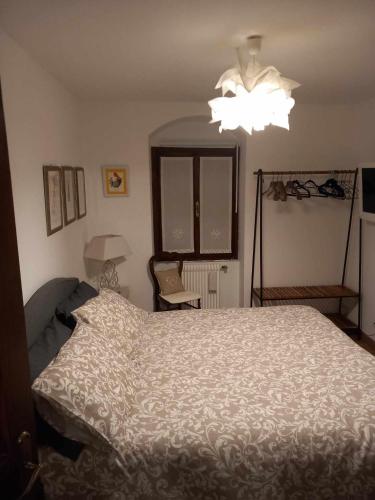 a bedroom with a bed and a chandelier at La Casa del Gallo in San Daniele del Friuli