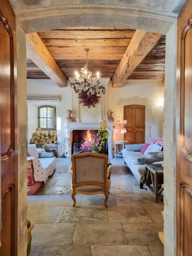 d'un salon avec une cheminée et un lustre. dans l'établissement Mas Des Cigales Lambesc, à Lambesc