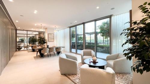 a living room with chairs and tables and windows at Best View In Dubai With FULL Burj Khalifa, Fountains, Park View, Next to Dubai Mall and Opera in Dubai