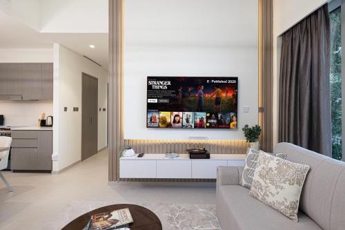 a living room with a couch and a tv on the wall at Best View In Dubai With FULL Burj Khalifa, Fountains, Park View, Next to Dubai Mall and Opera in Dubai