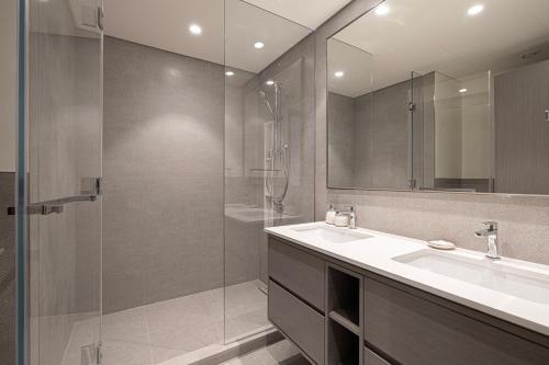 a bathroom with a sink and a glass shower at Best View In Dubai With FULL Burj Khalifa, Fountains, Park View, Next to Dubai Mall and Opera in Dubai