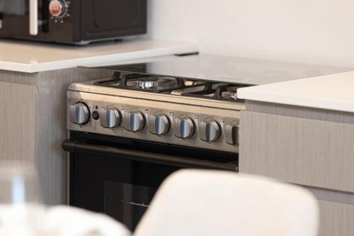 a stove top oven in a kitchen with a microwave at Best View In Dubai With FULL Burj Khalifa, Fountains, Park View, Next to Dubai Mall and Opera in Dubai