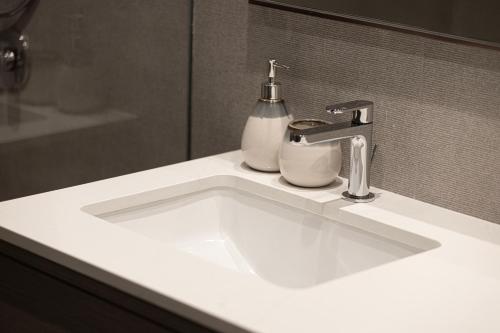 a white bathroom sink with a soap dispenser on it at Best View In Dubai With FULL Burj Khalifa, Fountains, Park View, Next to Dubai Mall and Opera in Dubai