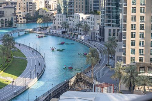 a river in the middle of a city with boats in it at Best View In Dubai With FULL Burj Khalifa, Fountains, Park View, Next to Dubai Mall and Opera in Dubai