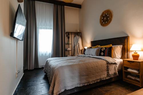 a bedroom with a large bed and a window at The Tribe Alpaca Retreat in Brăneşti
