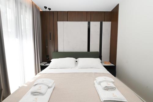 a bedroom with a large bed with two towels on it at La Onda Hotel Durres in Durrës