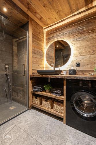 une salle de bain avec une machine à laver et un lavabo dans l'établissement Chalet Les Cocales Résidence Séjour et nuitées B&B - Appartement Pin Cembro, à Bessans