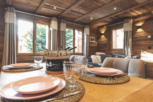 a dining room table with plates and glasses on it at Chalet Les Cocales - Séjour et nuitées - Appartement Pin Cembro in Bessans