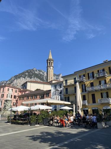 Un grupo de personas sentadas en mesas frente a un edificio. en Lake Front Apartments, Lecco, en Lecco