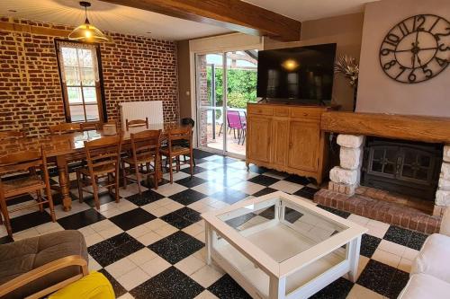 un salon avec cheminée et une salle à manger dans l'établissement Au petit bonheur à la campagne, à Lederzeele