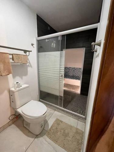 a bathroom with a toilet and a glass shower at Mini Casita, around nature in Santa Cruz de la Soledad