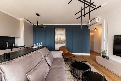 a living room with a couch and a kitchen at Klingerka Apartment, 25th floor with Free parking and view of Castle and Danube in Bratislava