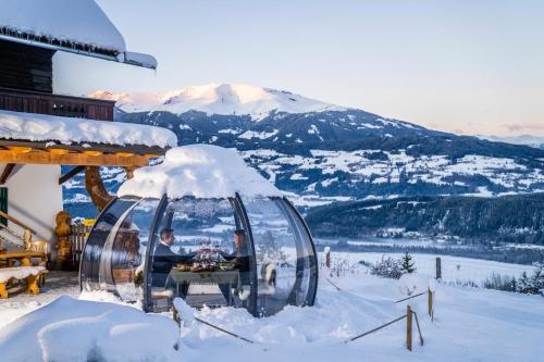 a man is sitting in a igloo in the snow at Landgasthof Marhube in Baldramsdorf