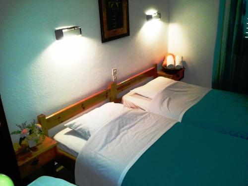 a bedroom with a bed and two lights on the wall at skiathosrooms-appartments for holidays in Skiathos Town