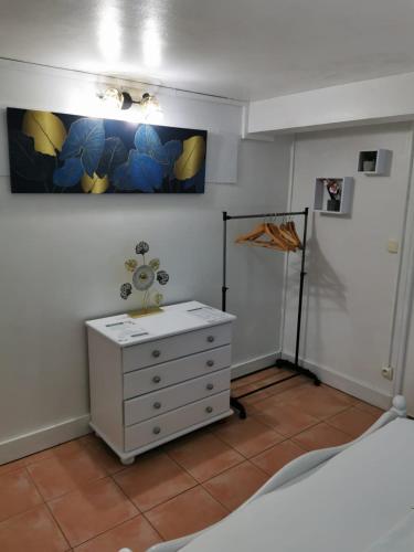 a bedroom with a dresser and a painting on the wall at Les Gîtes de la Lézarde in Petit-Bourg