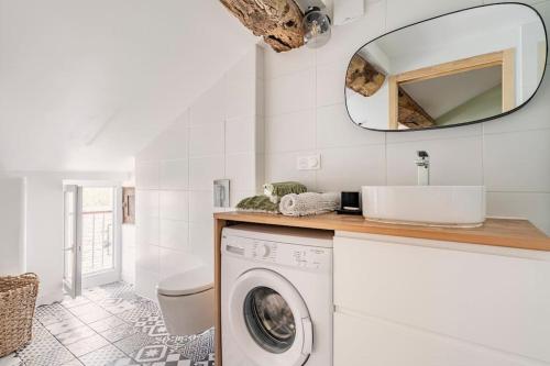 La salle de bains est pourvue d'un lave-linge et d'un miroir. dans l'établissement Citadelle de Bastia - duplex - vue mer, à Bastia