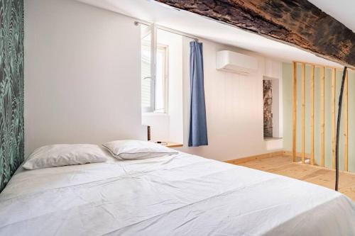 - une chambre avec un lit blanc et un rideau bleu dans l'établissement Citadelle de Bastia - duplex - vue mer, à Bastia