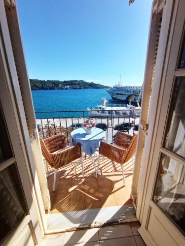 a balcony with a table and chairs with a view of the water at skiathosrooms-appartments for holidays in Skiathos Town