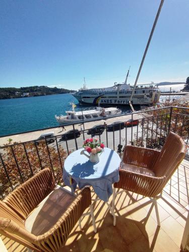 a balcony with a table and chairs and a boat at skiathosrooms-appartments for holidays in Skiathos Town