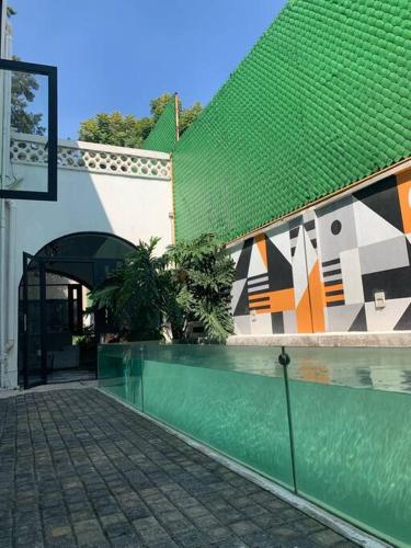 a green and white building with a green roof at Nuevo Loft con Gym con Alberca y Terraza in Mexico City