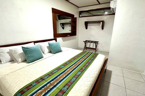 Un dormitorio con una gran cama blanca con almohadas azules. en Sweet Home, en Puerto Ayora