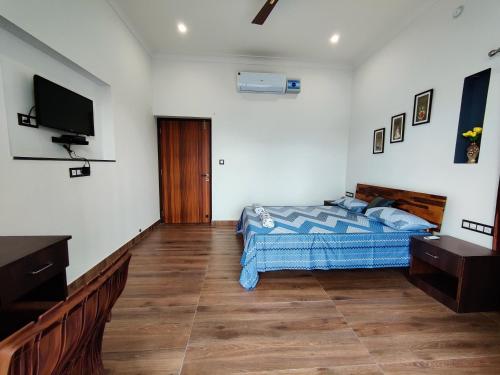 a bedroom with a bed and a flat screen tv at Chitrangan The Homestay of Udaipur in Udaipur
