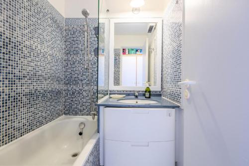 une salle de bain avec une baignoire, un lavabo et un miroir dans l'établissement Résidence le Hameau de Cap Esterel - maeva Home - Appartement 2 pièces 5 personnes - Sélection MAE-0051, à Saint-Raphaël